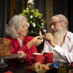 Beau Couple De Personnes Agees Ayant Des Biscuits De Noel